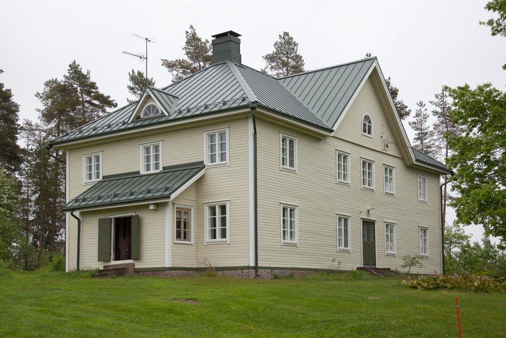 Rakennus kesäisessä maisemassa.