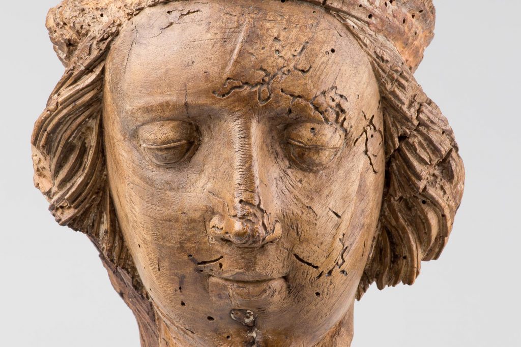 Wooden sculpture of a face of a human.