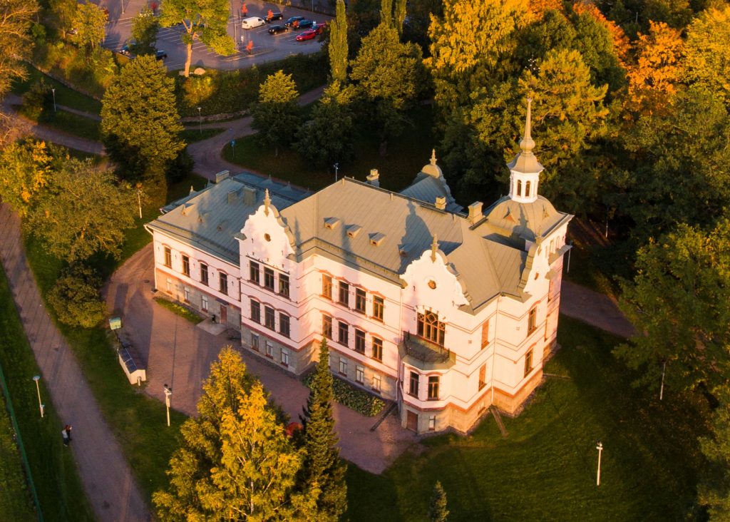 Ilmakuva Lahden historiallinen museosta. Kuvaushetkellä aurinko on laskemassa ja valo on lämpöisen sävyinen.