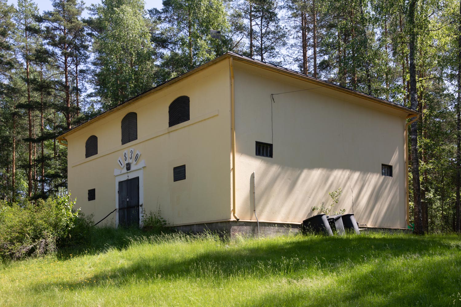 Vaalea makasiinirakenussa, jonka suljetun oven päällä vuosiluku 1830.