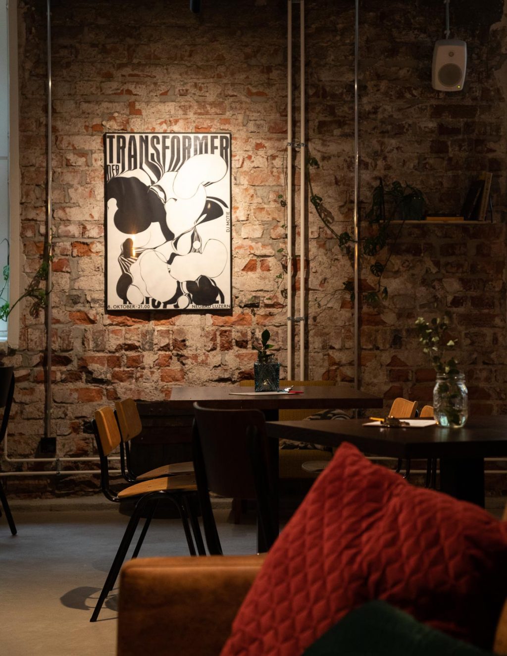 A restaurant. Table groups, mood lighting, a poster on a brick wall. An old radio on a windowsill.